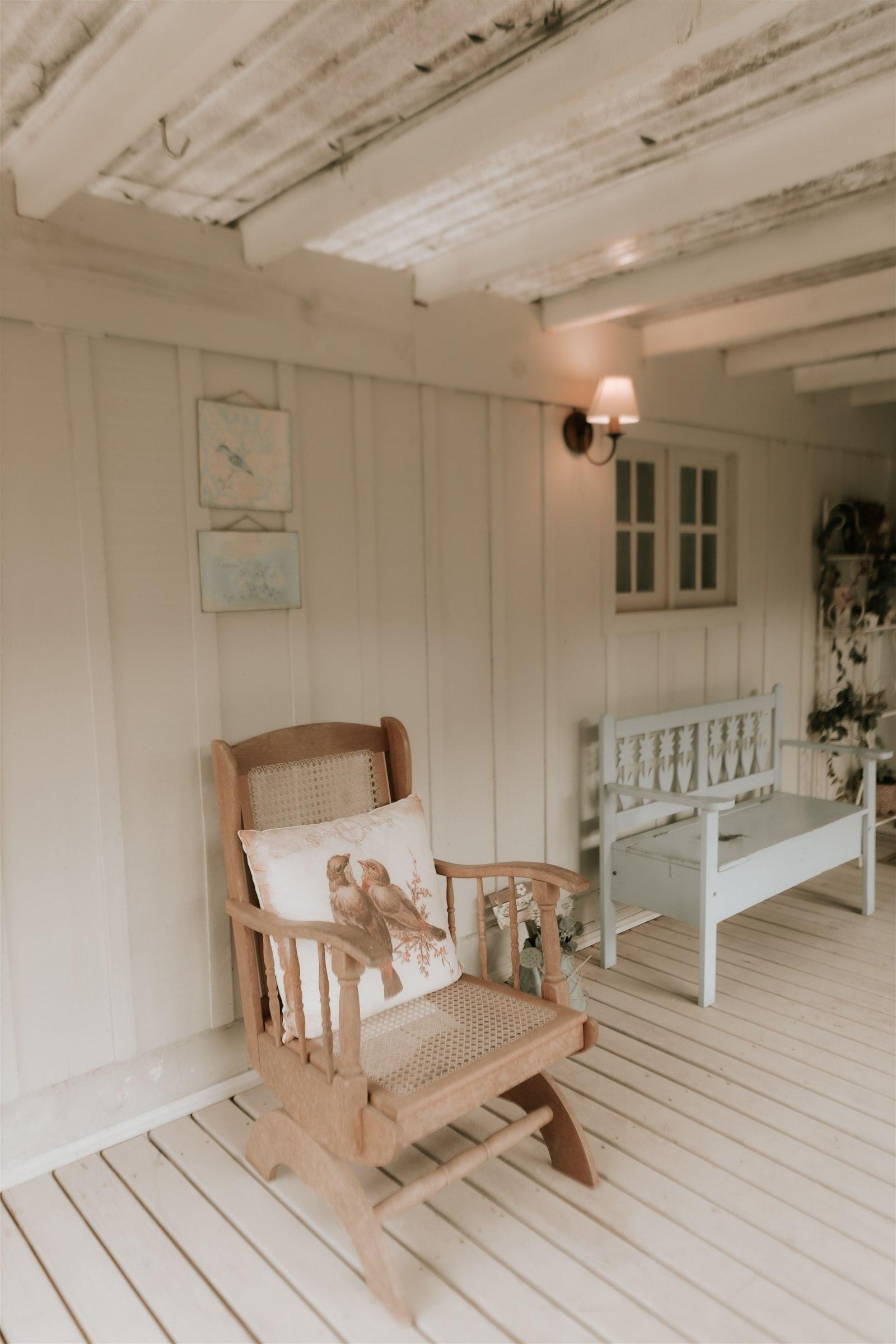 Covered residential porch with painted wood walls and seating